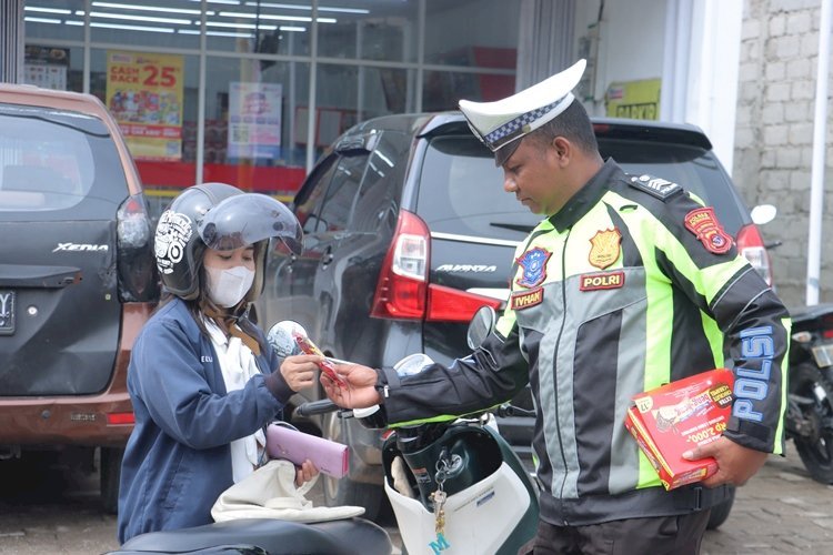 Lantas  Unik, Anggota Polres TTS Bagi  Makanan Beng-beng  Sambil  Imbau Kamseltibcarlantas
