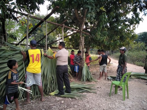 Bhabinkamtibmas Desa Holoama Bantu Warga Desa Binaannya Dirikan Pos Kamling