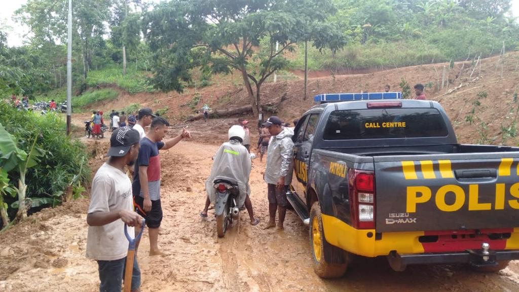 Personel Polsek Alor Selatan Gotong Royong Bersama Masyarakat Bersihkan Material Tanah yang Menutupi Jalan
