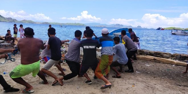 Bentuk Perhatian Polri Kepada Nelayan, Bhabinkamtibmas Desa Komodo Bantu Mengangkat Perahu ke Daratan